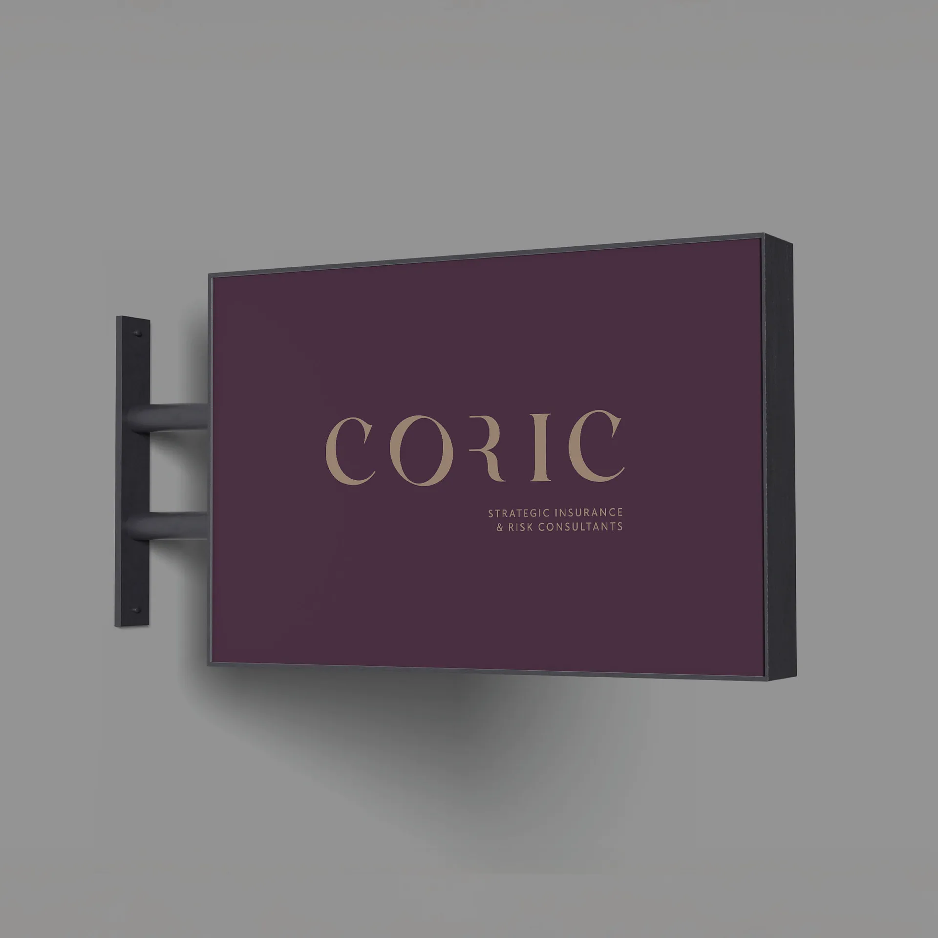 Wall-mounted rectangular sign with dark purple background and gold text reading 'CORIC Strategic Insurance & Risk Consultants’.