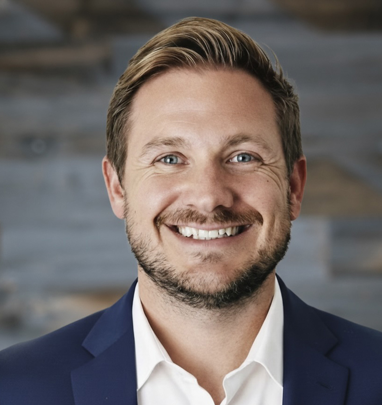 A Professional headshot of Dr. Ched Garten, Founder and CEO of Paragon Sports Medicine, wearing a suit and smiling confidently.