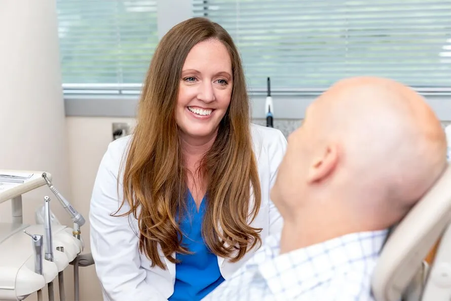 Dr. Jennie Austin smiling at a patient in the dental chair.