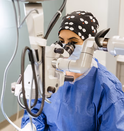 veterinary ophthalmologist performing surgery at microscope