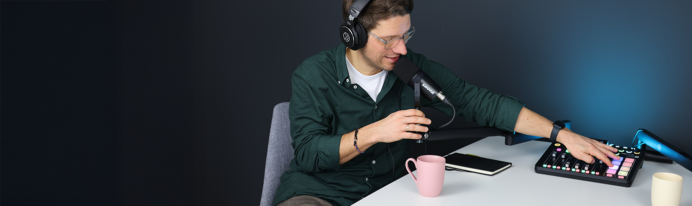 Journalist Cliff Lehnen sitzt in seinem Podcast Studio bei der Aufnahme