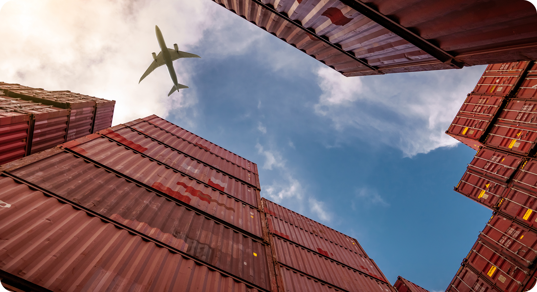 Airplane flying over stacked shipping containers for air freight logistics