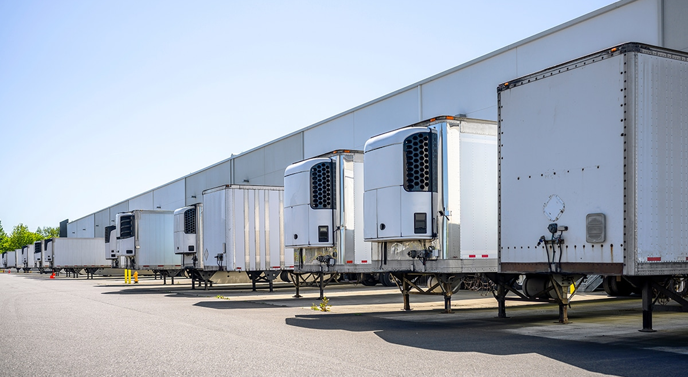 Refrigerated trailers parked at warehouse loading docks for cold chain logistics
