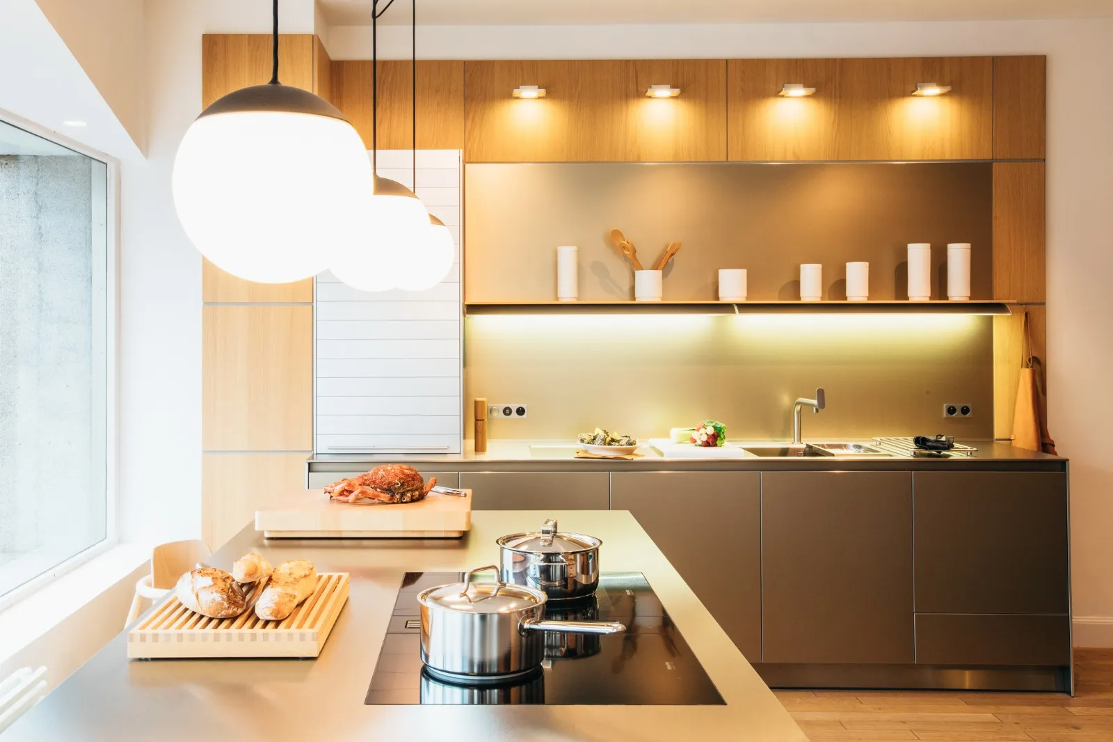 Cuisine sur-mesure en bois avec îlot central et suspensions boules