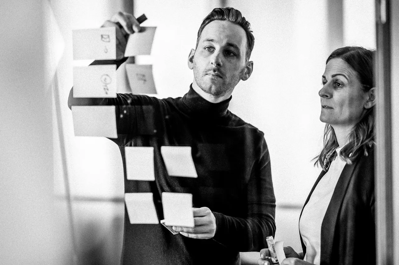 Pierre Fey und Tanja Fey – Geschäftsführer und Geschäftsführerin von Fey Consulting, Experte für Unternehmensberatung vor einem whiteboard mit notizzetteln, strategische Planung für unternehmen