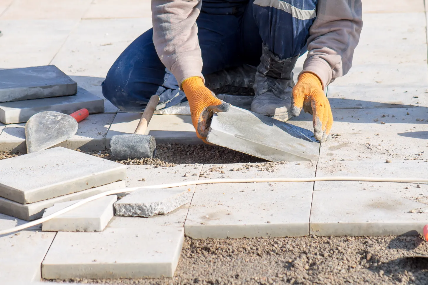 A Bright Solution employee laying stone tiles on a commercial property in London