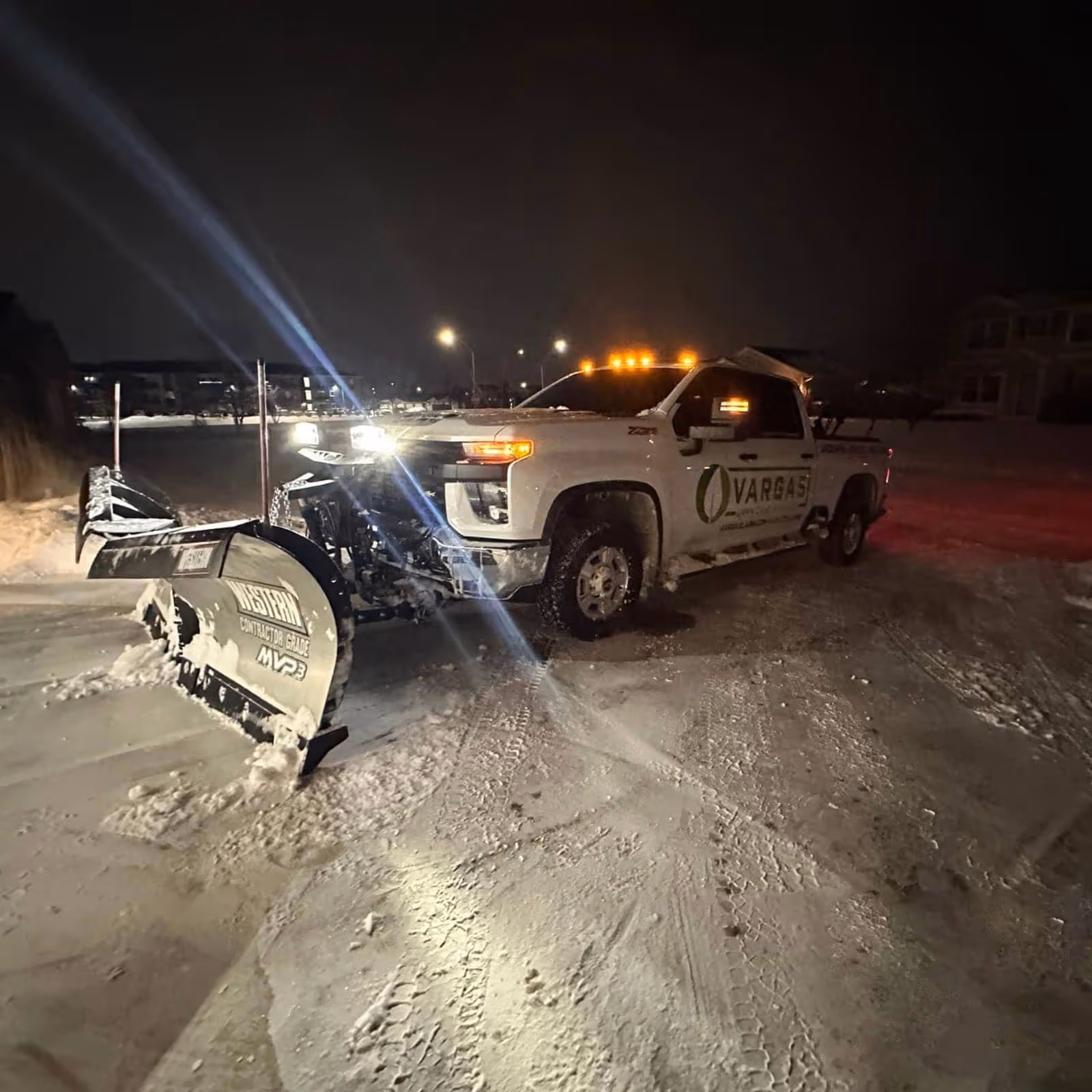 Snow plow truck clearing commercial parking lot by Vargas Lawn Care Services in Johnston Iowa near me