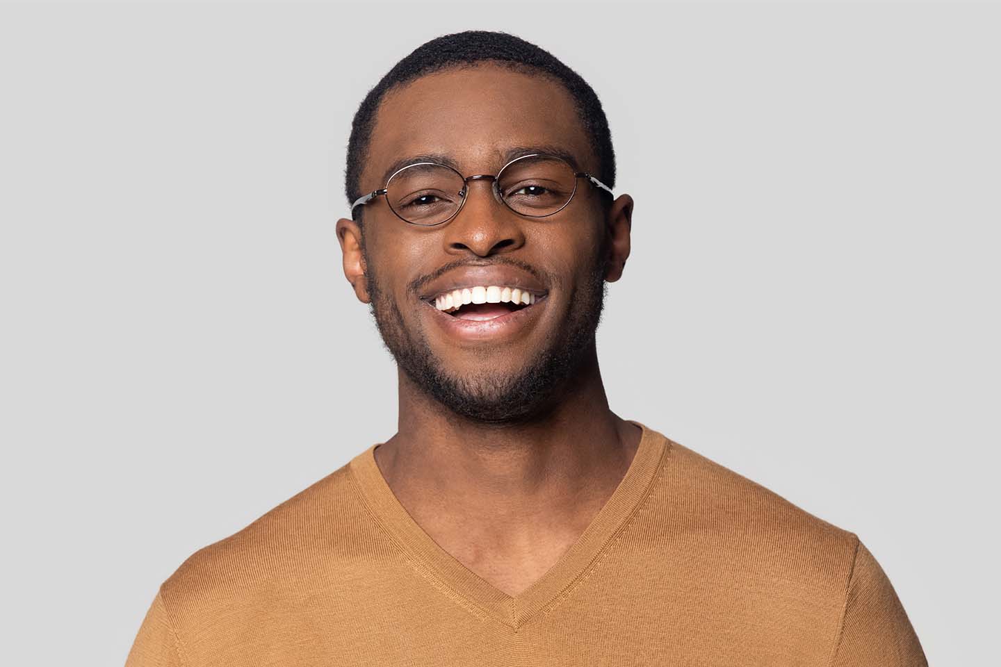 A man wearing glasses and a v - neck shirt.
