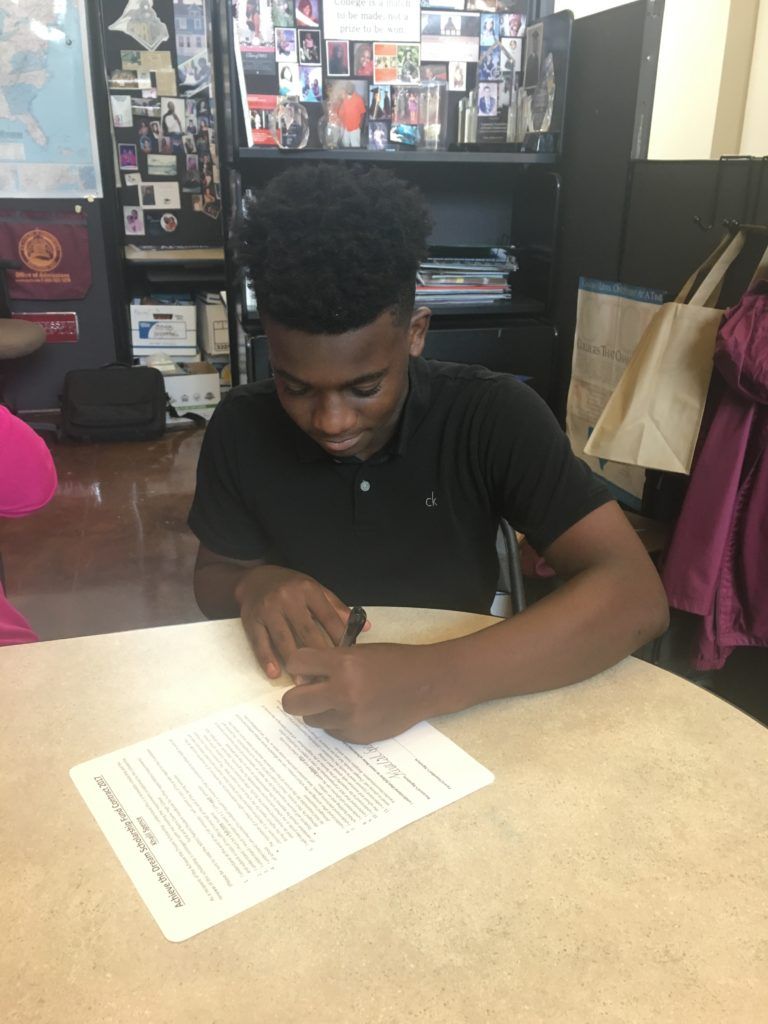 A young student works at a desk.