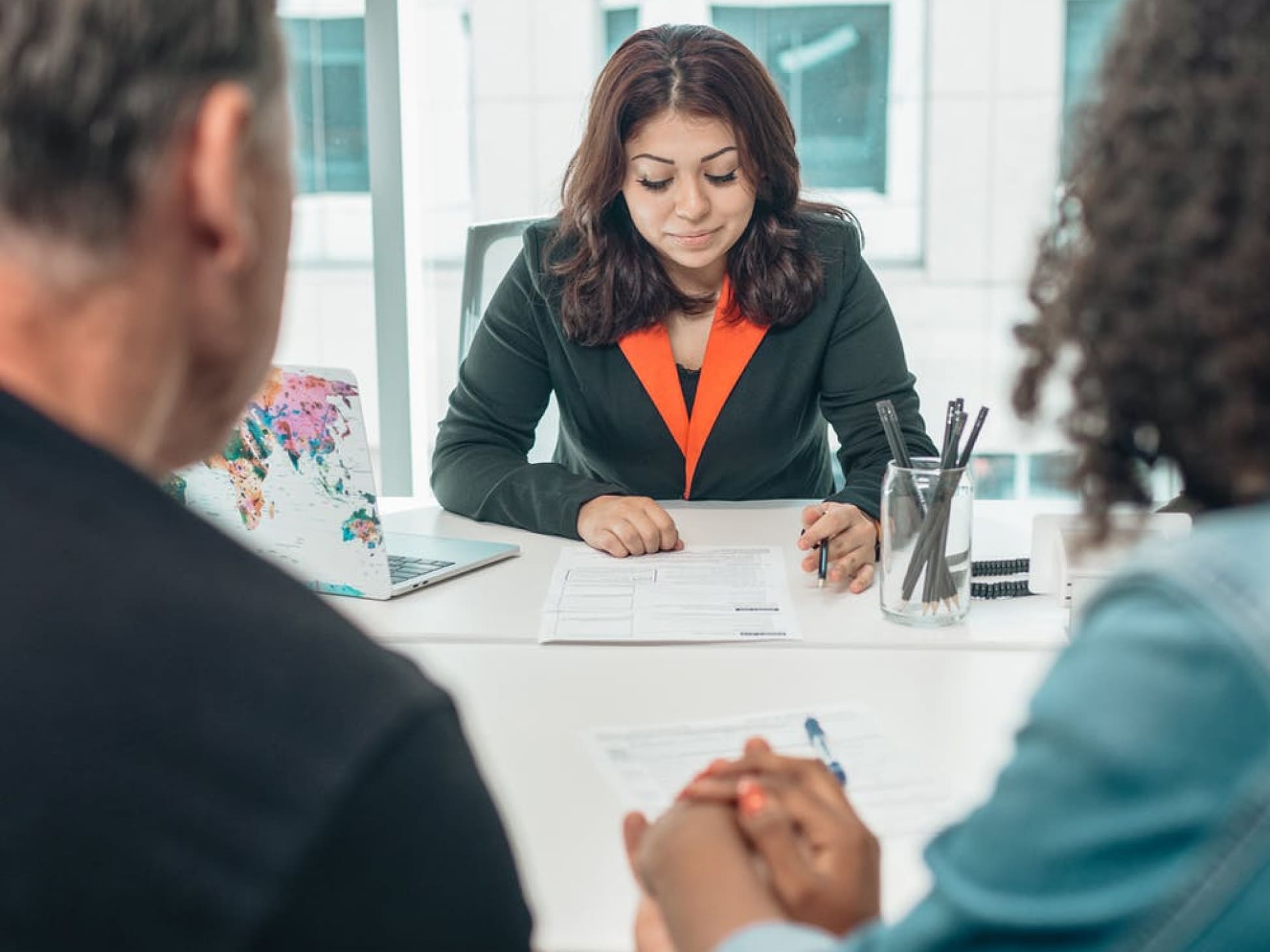 A couple meets with a financial advisor around a conference table.