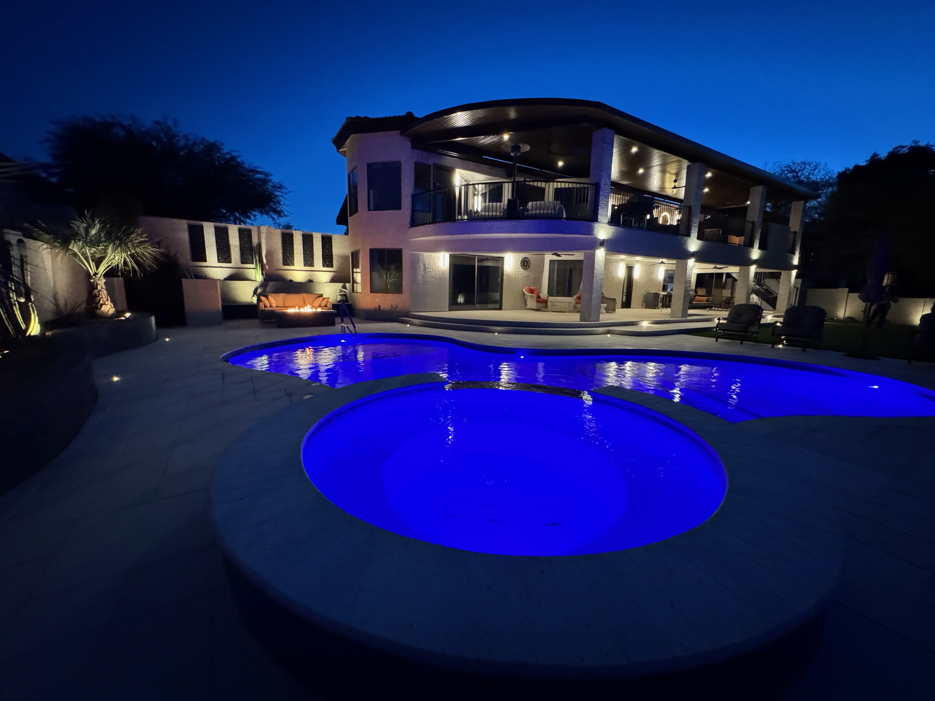 Luxury hillside pool at sunset with integrated spa, fire features, and outdoor living area in Paradise Valley