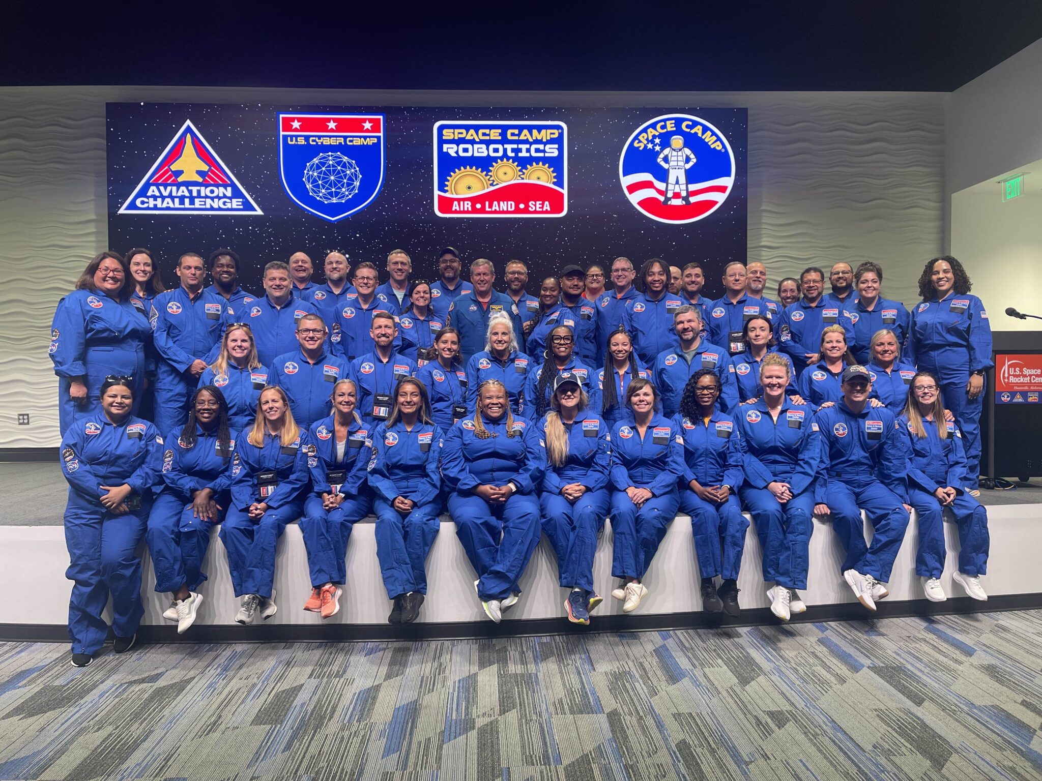 Image of a group of people in blue jumpsuits at space camp. 