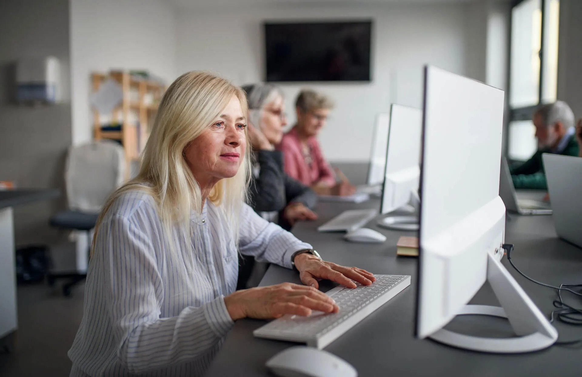 Senior woman working on computer in office.
