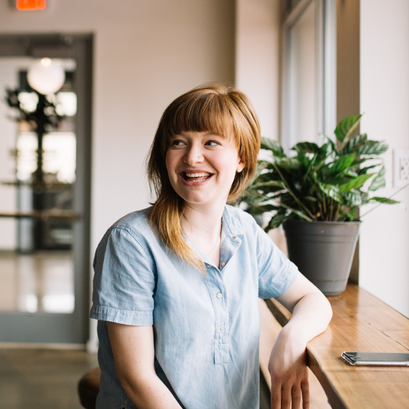 Smiling professional at her desk during LeadIN™ leadership development coaching