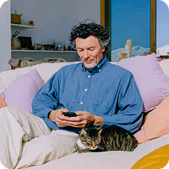 Homme sur un canapé au téléphone avec son chat