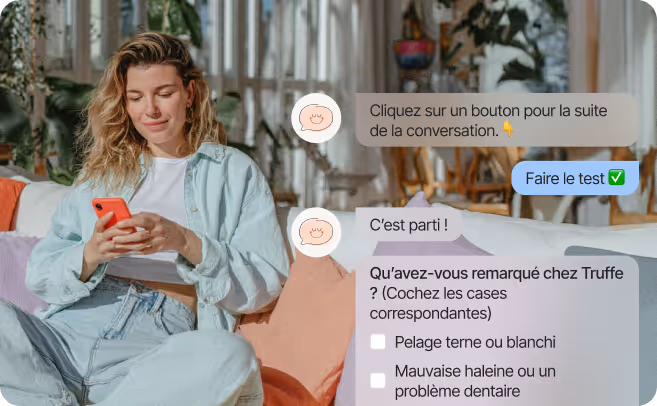 Jeune femme assise sur un canapé, souriante, tenant un téléphone rouge avec une conversation en français affichée à côté.