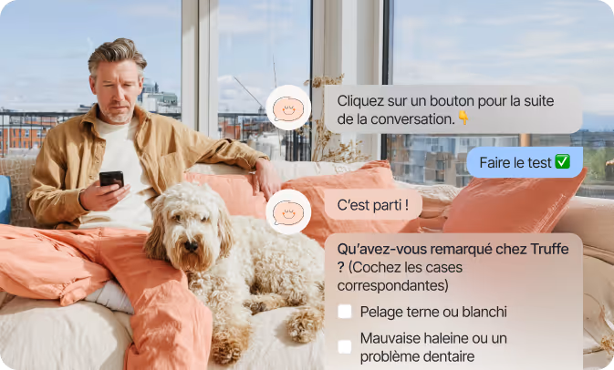 Un homme assis sur un canapé avec un chien blanc bouclé à côté de lui, regardant son smartphone ; une conversation texte en français est affichée à l'écran avec des instructions pour un test sur les observations concernant le chien nommé Truffe.