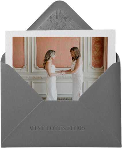 Photo of two women in white dresses holding hands and facing each other inside an elegant room with ornate walls, displayed in a gray envelope labeled 'Mint Lotus Films'.