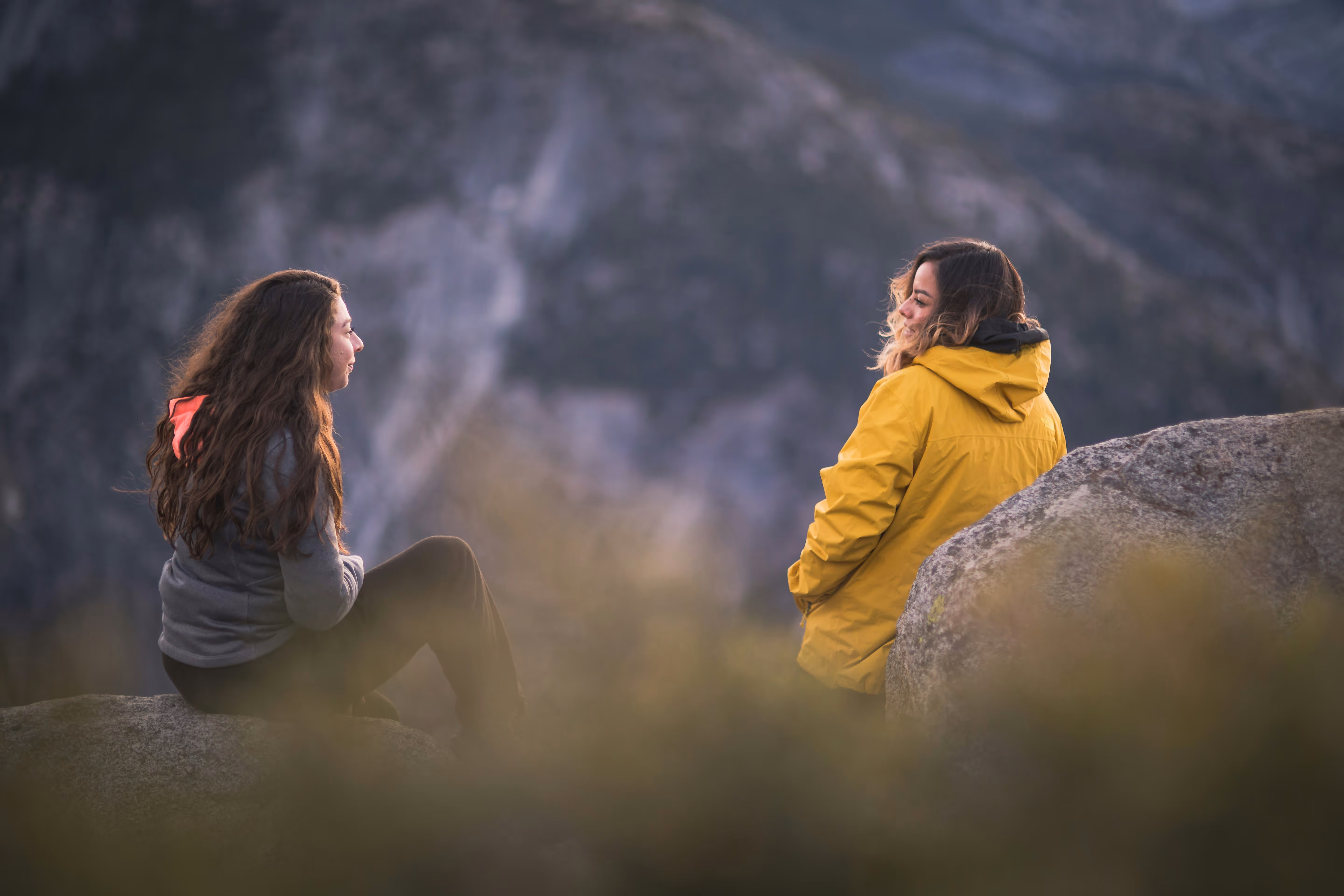 Women talking to each other smiling in the mountains.