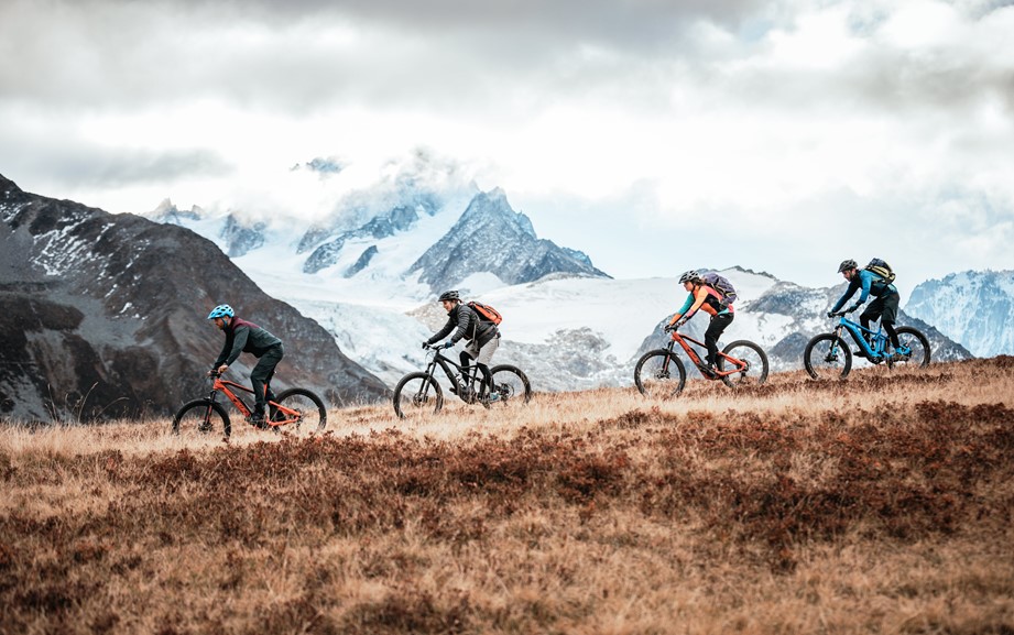 Four mountain bikers riding at the foot of the Mont Blanc
