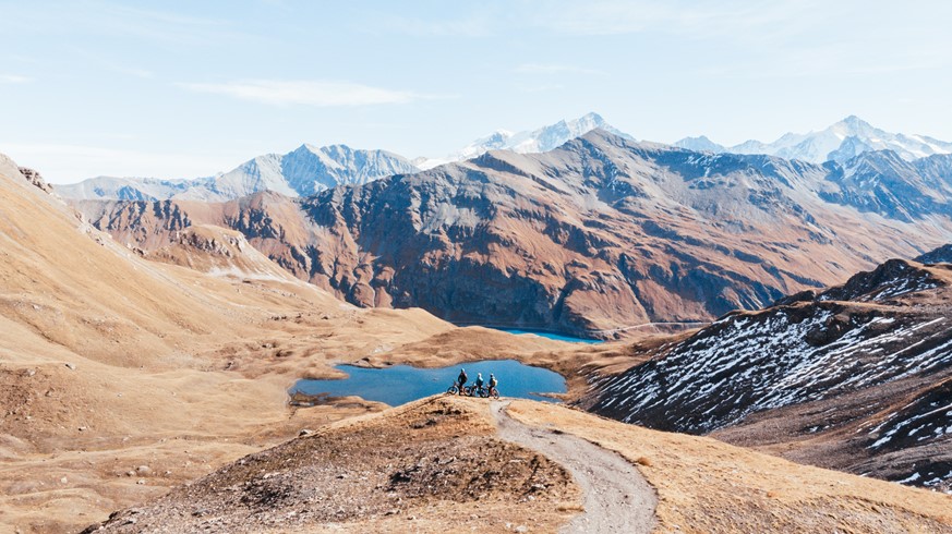 Three riders admiring Swiss peaks, including the Dent Blanche, in Val d'Anniviers