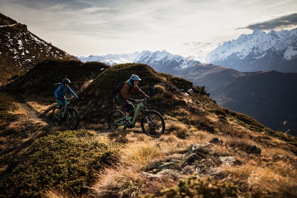 Two riders with the Alps in the background