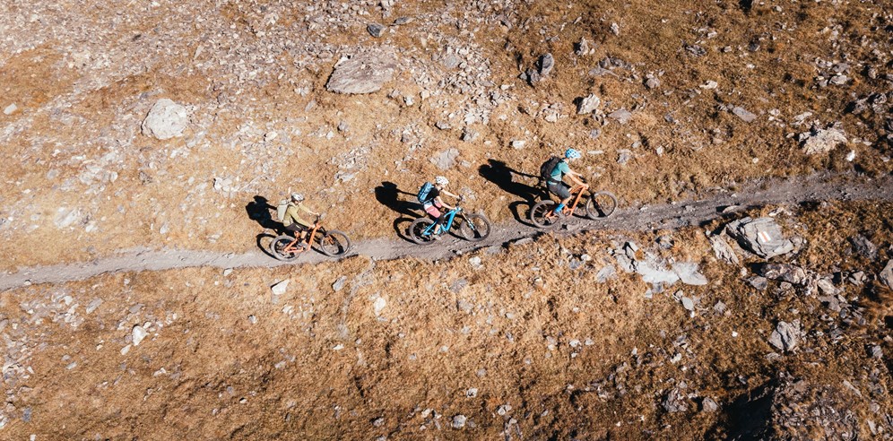 Three riders mountain biking on a technical balcony single track trail