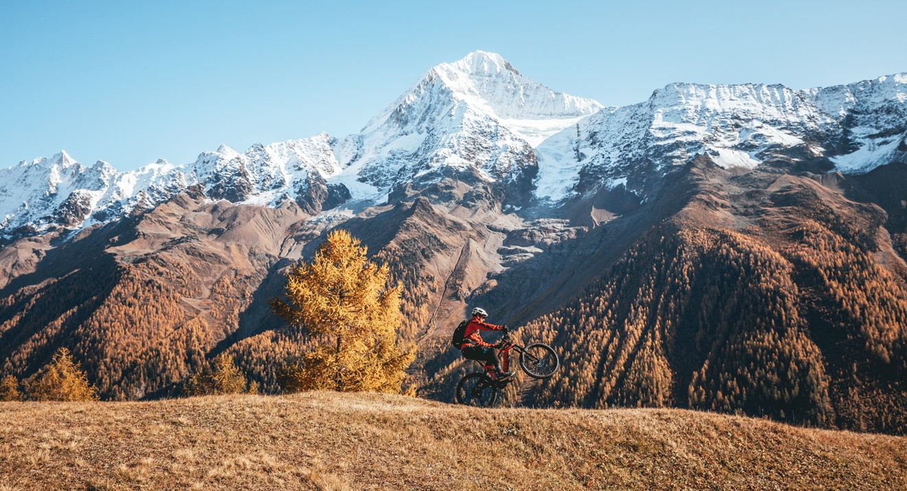 Man doing a wheelie with the Alps as his backdrop