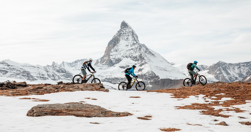 Three riders riding  their e-bikes with the Matterhorn in the background