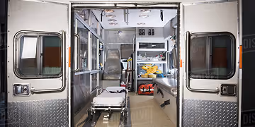 Inside view of an ambulance showing medical equipment and stretcher.