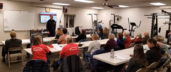 Fire department leader teaching a community safety class in a meeting room.