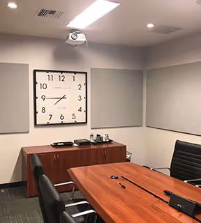 An empty conference room with a clock on the wall.