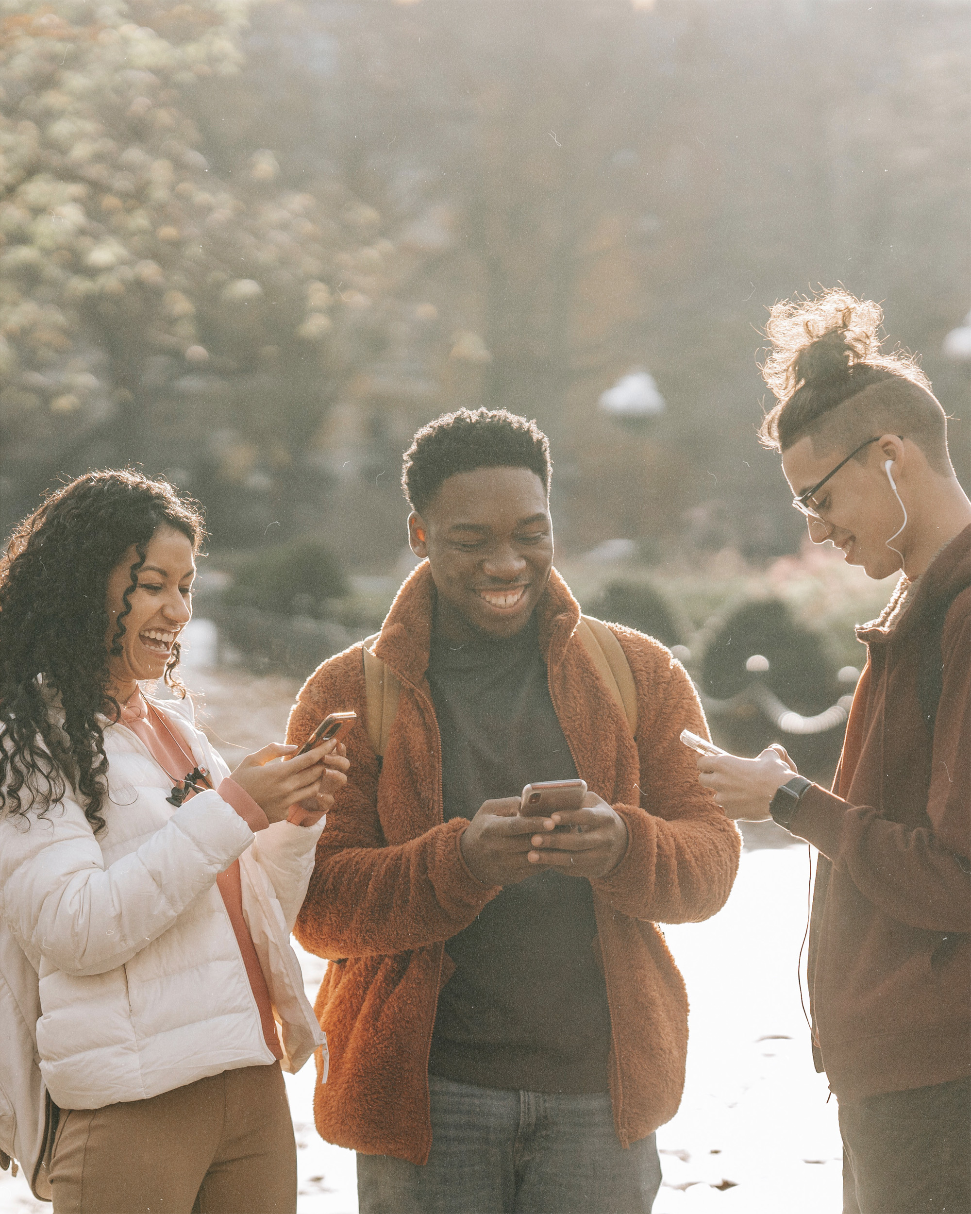 Young adults on their phones smiling
