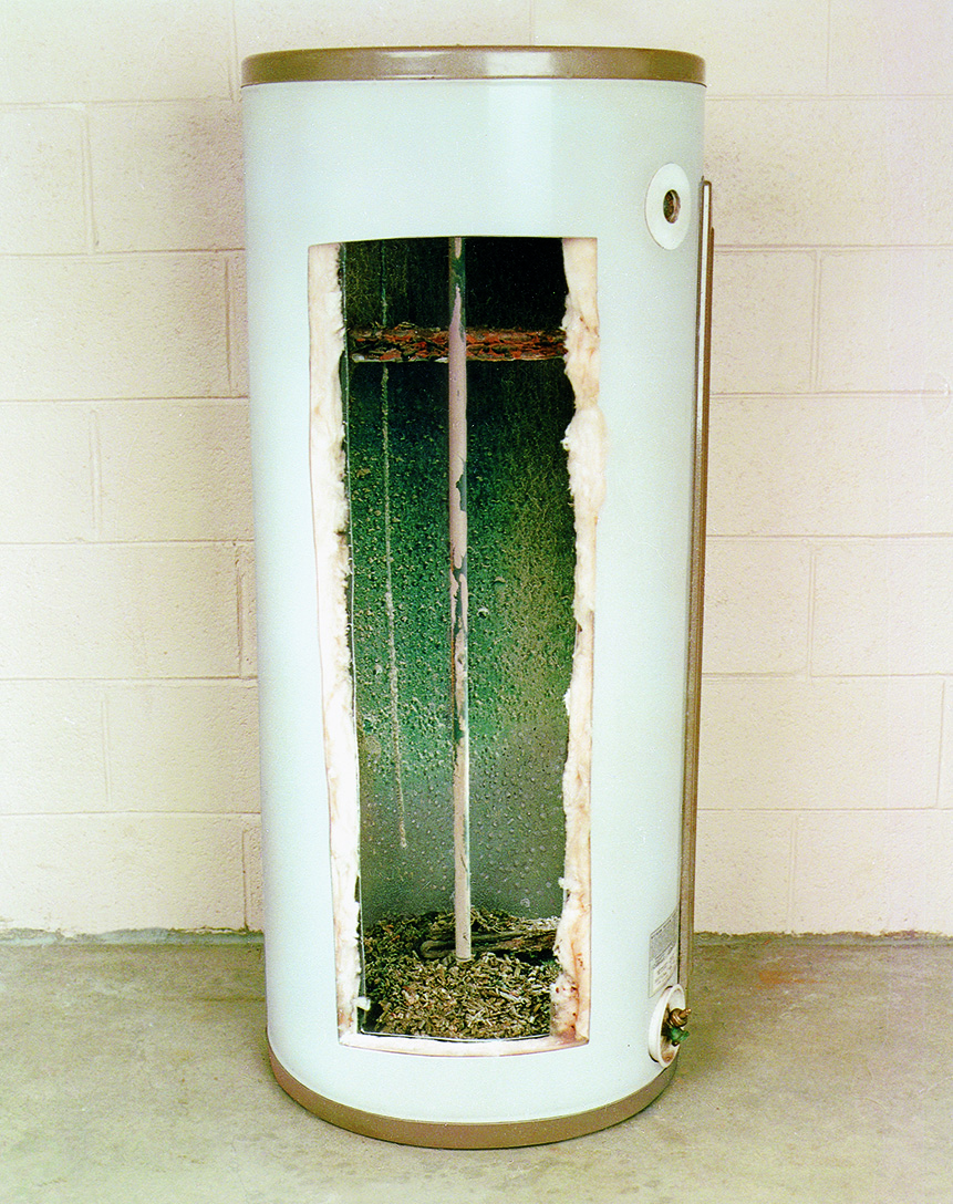 Vertical cutaway view of a water heater showing internal parts including insulation, dip tube, and sediment at the bottom.
