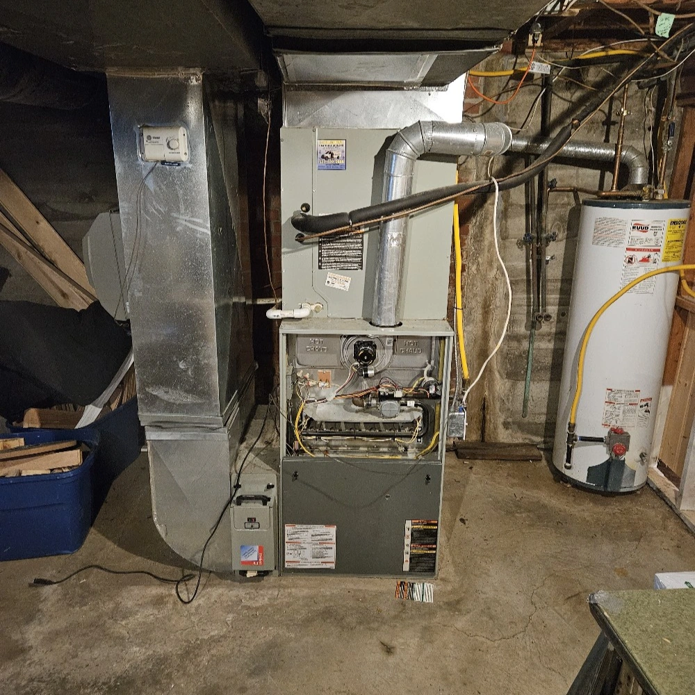 A basement with an exposed furnace and water heater. 