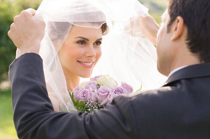 Groom lifts his bride’s veil to reveal her beautiful smile before saying “I do.”