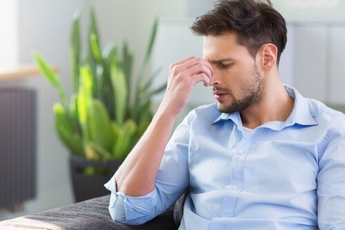 man rubbing forehead from headache