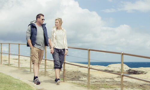 Middle age couple walking down to beach