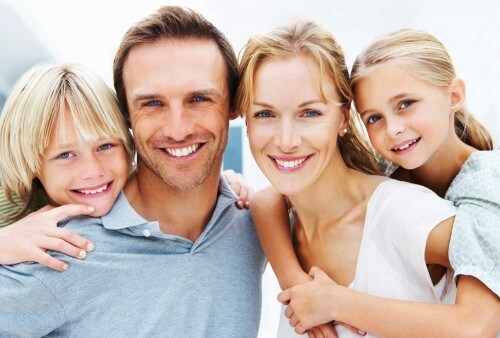 family smiling with kids on their backs