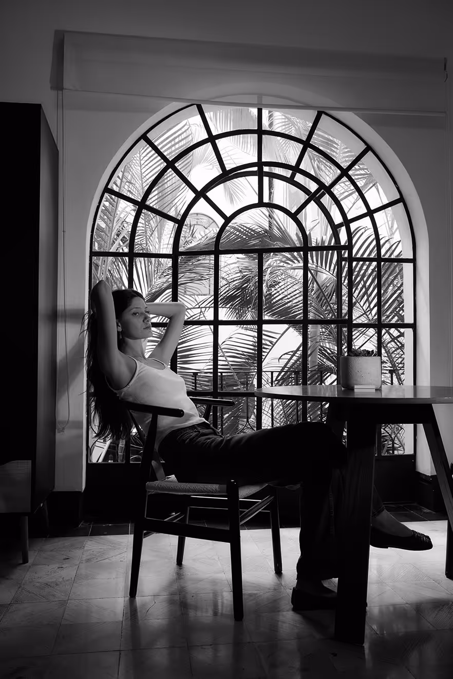 A serene morning view in a room, a woman is drinking coffe in black and white.
