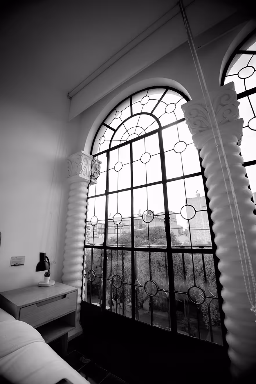 A cozy bedroom with soft lighting and giant windows.