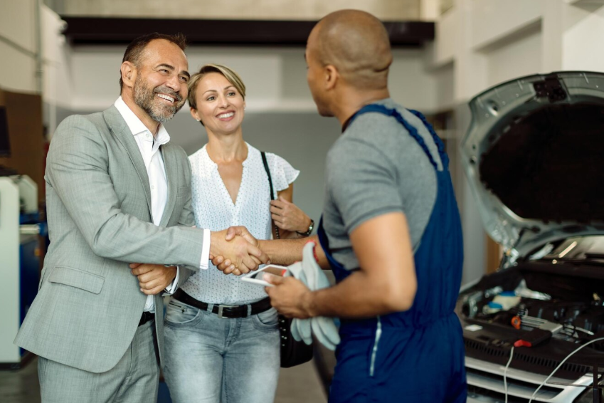 A mechanic greeting and shaking hands with customers