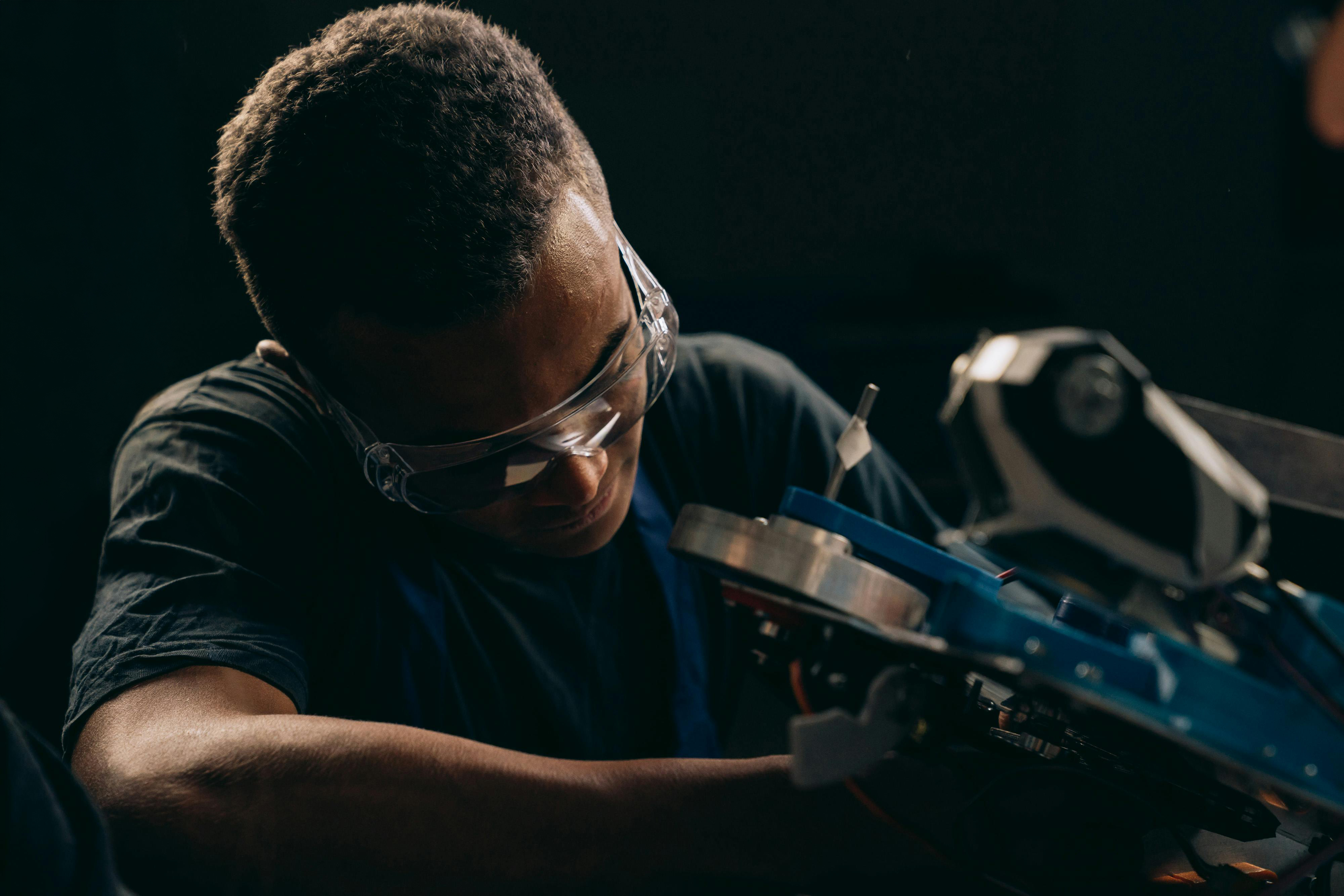 A mechanic wearing safety glasses working with machinery