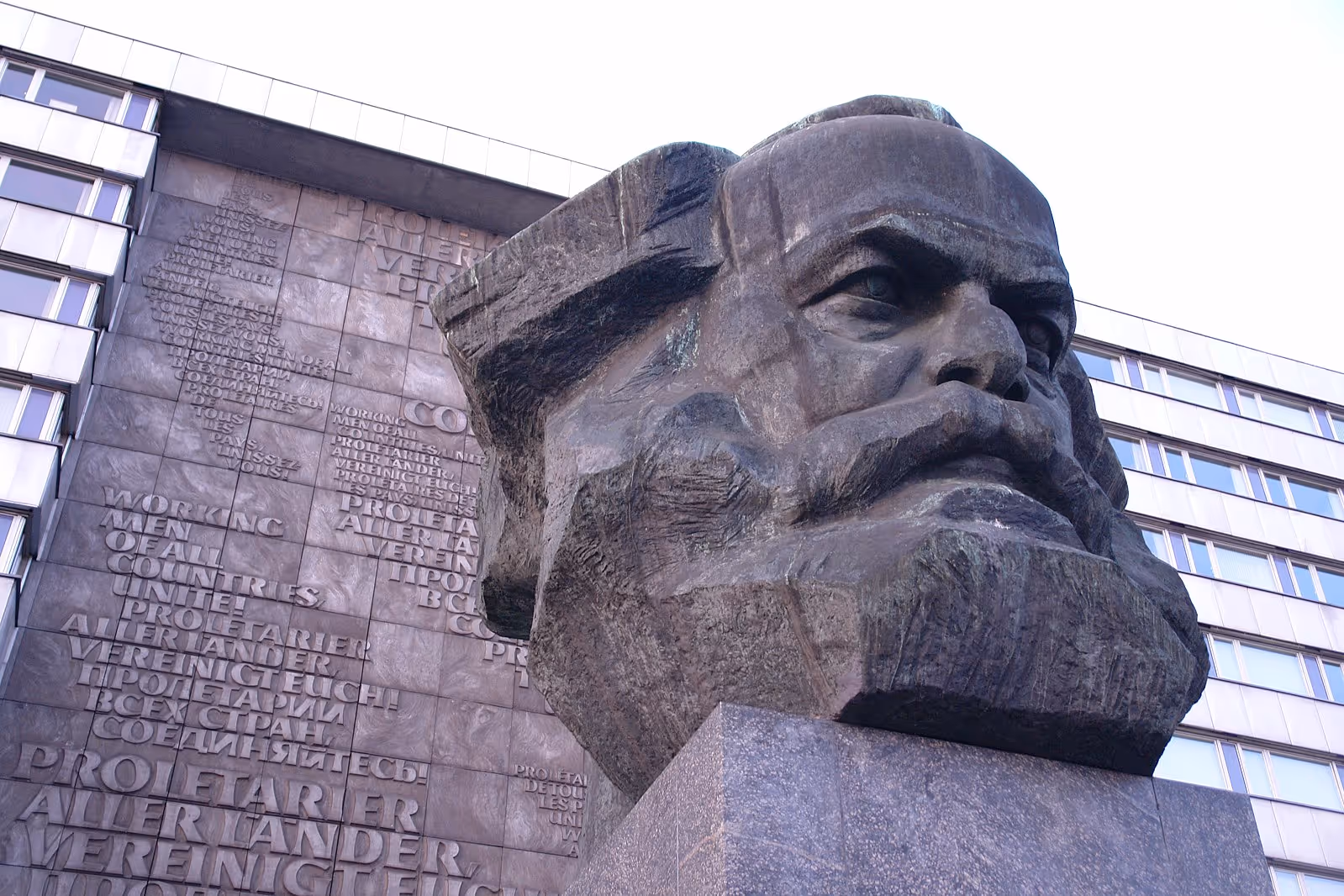 A dramatic, low-angle shot of a colossal bronze bust of a historical figure