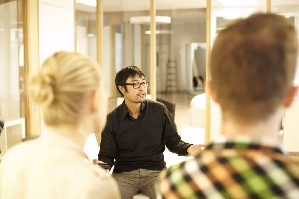 A candid, close-up shot of several people engaged in conversation in a hallway or common area.