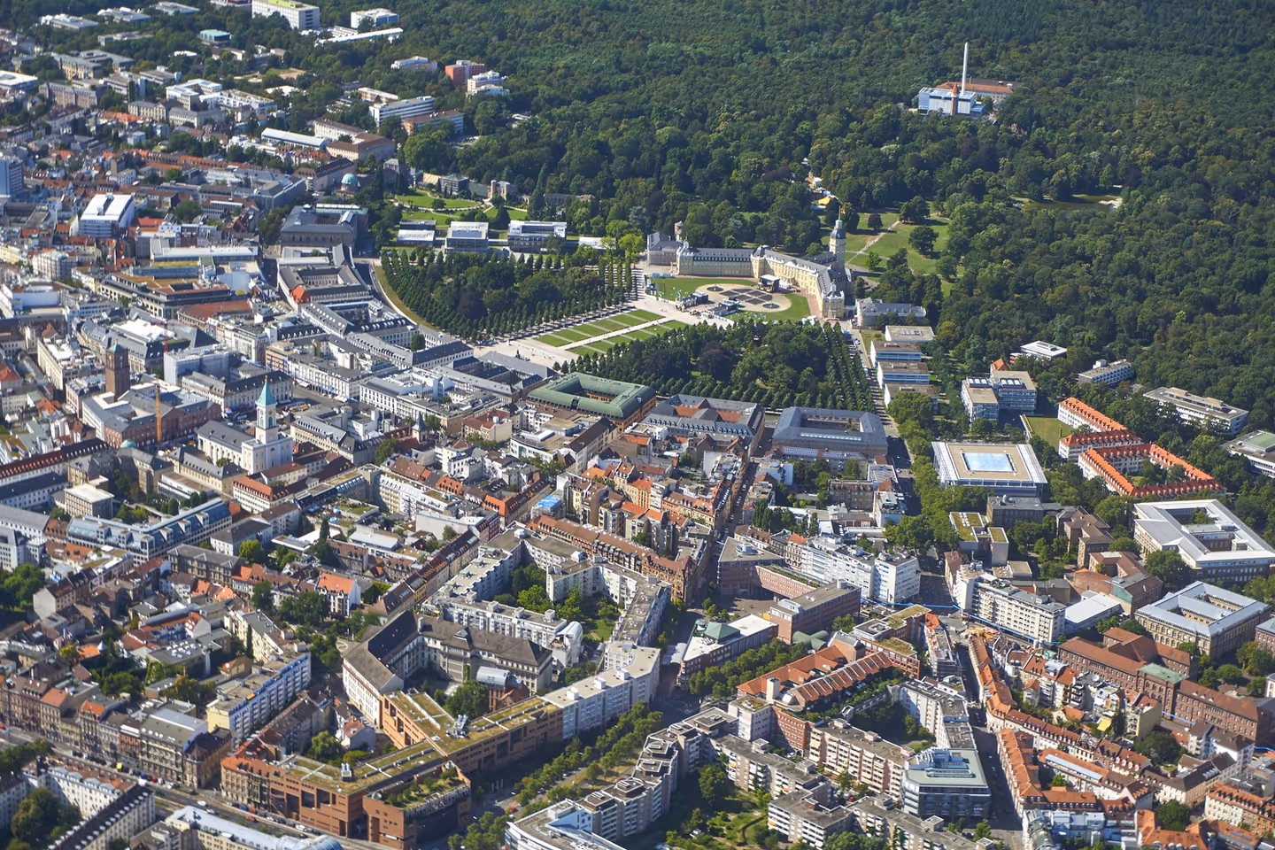 A high aerial view of a European city, showing a dense urban area with a mix of buildings and trees.