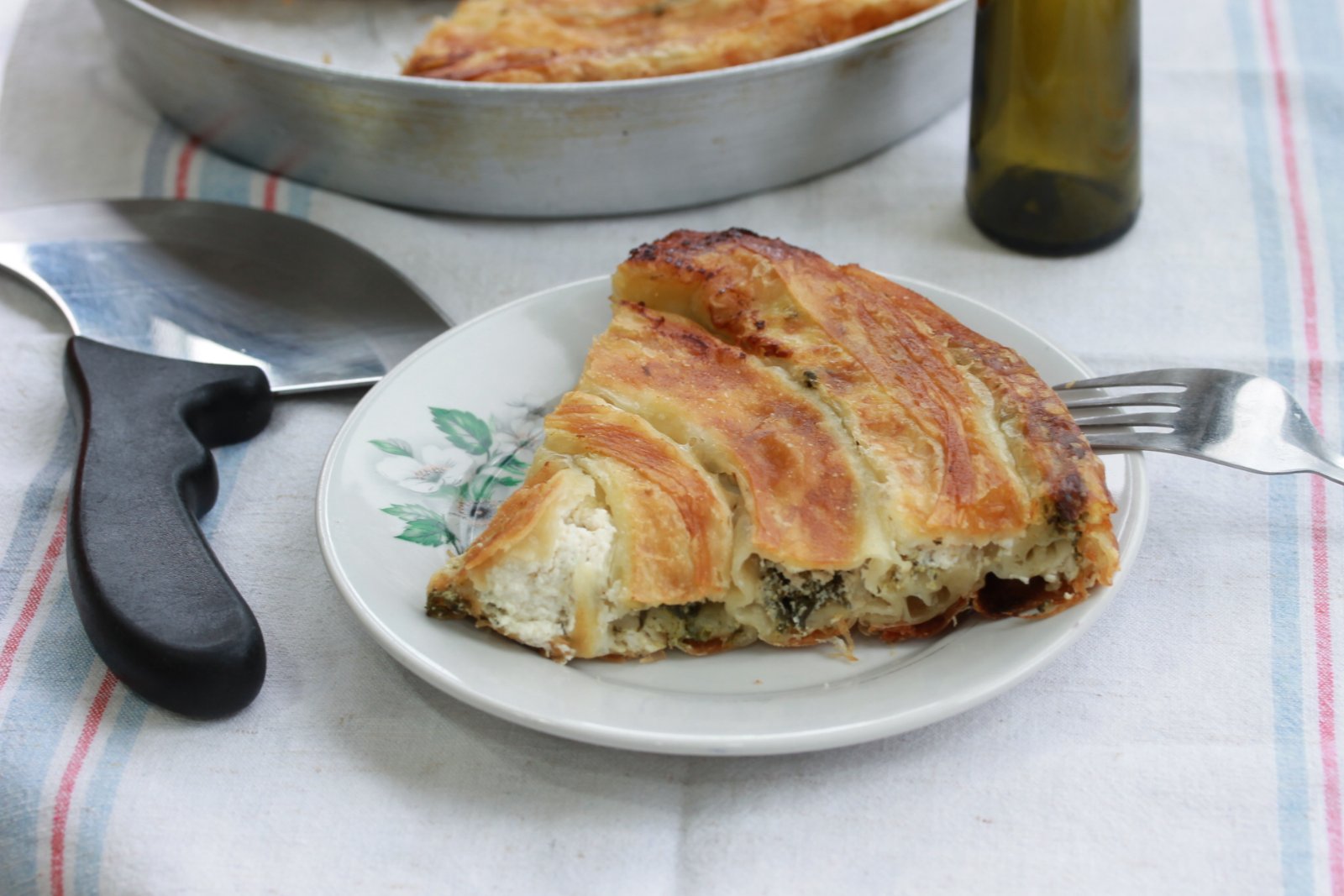 Burger with fried fries on black plate with sauce on the side