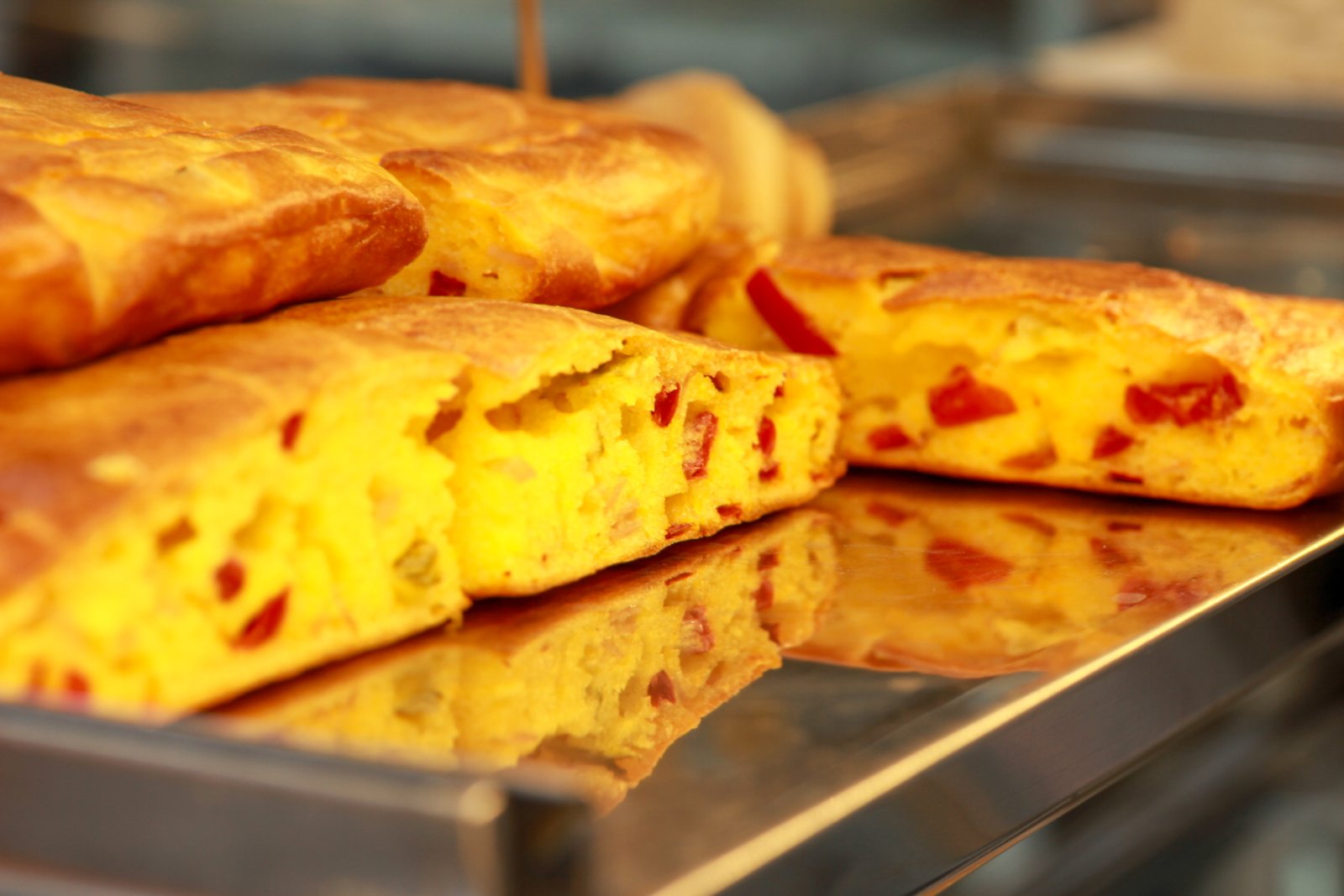 Positive young multiracial friends eating fast food and drinking beer in outdoor cafe