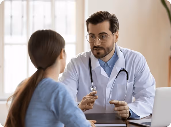 Male physician and female healthcare professional collaborating at a desk on a clinical documentation solution