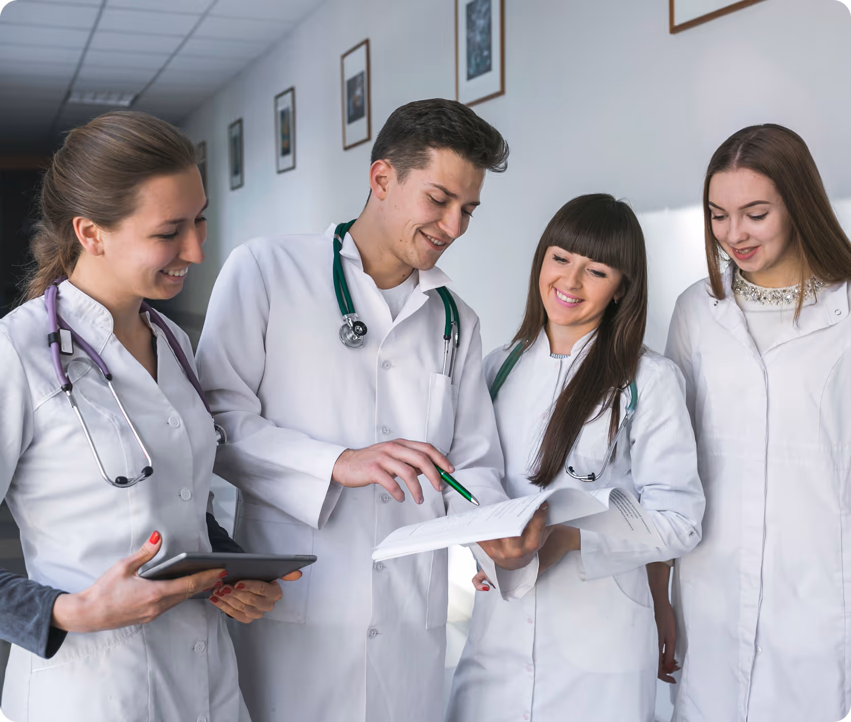 Four healthcare professionals in white coats collaborating and reviewing documents together